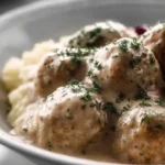 Plate of homemade Swedish chicken meatballs served with a creamy sauce.