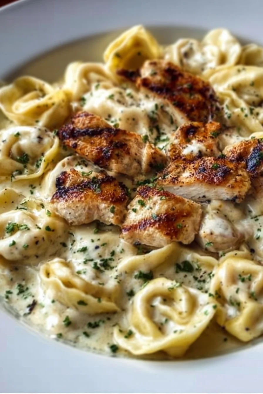 Asiago Tortelloni Alfredo with Grilled Chicken on a plate garnished with herbs